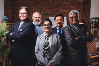 Hintli üst düzey iş adamlarının portresi gülümseyerek alkışlarken, Hintli üst düzey Asyalı yöneticiler modern şirket işyerindeki kameralara bakarak başarıyı alkışlıyor ve kutluyorlar.