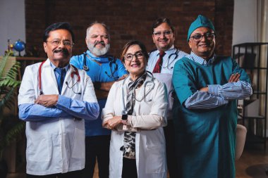 Hintli kendine güvenen doktorlar, modern hastane sağlık hizmetleri koğuşunda kendilerine güveni tam olan kıdemli cerrahların ve doktorların fotoğraflarına bakıyorlar.