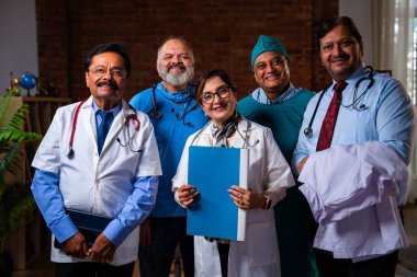 Hintli kendine güvenen doktorlar, modern hastane sağlık hizmetleri koğuşunda kendilerine güveni tam olan kıdemli cerrahların ve doktorların fotoğraflarına bakıyorlar.