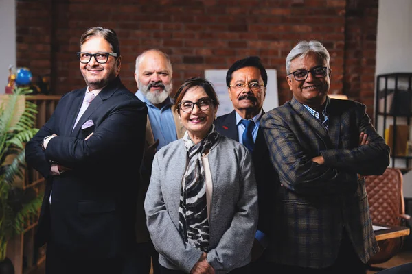 Hintli üst düzey iş adamlarının portresi gülümseyerek alkışlarken, Hintli üst düzey Asyalı yöneticiler modern şirket işyerindeki kameralara bakarak başarıyı alkışlıyor ve kutluyorlar.