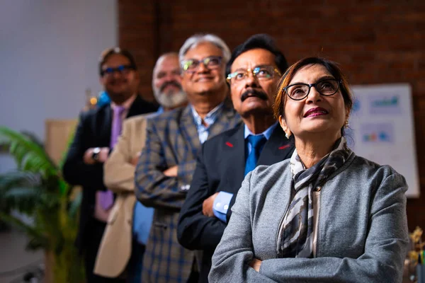 Hintli beş iş adamı sunum ve alkışları Hintli üst düzey Asyalı iş adamlarına yakın plan olarak görüyor ve modern ofis içinde masada otururken veya ayakta dururken başarılı brifing veriyorlar.