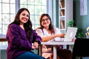 Modern klinikte gülümseyen, kıdemli tıbbi uzmanlık, hasta güveni, pozitif sağlık ilişkisi ve kendine güven gösteren Hintli kadın doktor kameraya bakıyor.