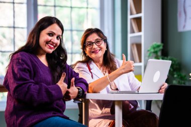 Modern klinikte gülümseyen, kıdemli tıbbi uzmanlık, hasta güveni, pozitif sağlık ilişkisi ve kendine güven gösteren Hintli kadın doktor kameraya bakıyor.