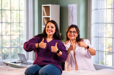 Modern klinikte gülümseyen, kıdemli tıbbi uzmanlık, hasta güveni, pozitif sağlık ilişkisi ve kendine güven gösteren Hintli kadın doktor kameraya bakıyor.
