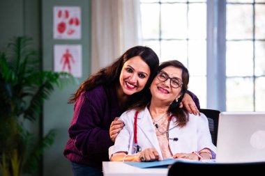 Modern klinikte gülümseyen, kıdemli tıbbi uzmanlık, hasta güveni, pozitif sağlık ilişkisi ve kendine güven gösteren Hintli kadın doktor kameraya bakıyor.