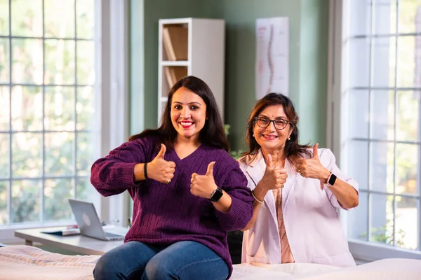 Modern klinikte gülümseyen, kıdemli tıbbi uzmanlık, hasta güveni, pozitif sağlık ilişkisi ve kendine güven gösteren Hintli kadın doktor kameraya bakıyor.