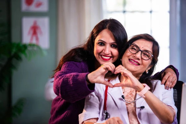 Modern klinikte gülümseyen, kıdemli tıbbi uzmanlık, hasta güveni, pozitif sağlık ilişkisi ve kendine güven gösteren Hintli kadın doktor kameraya bakıyor.