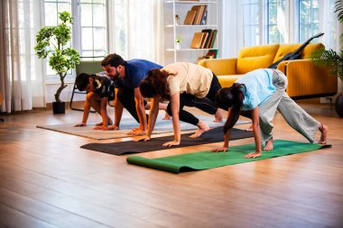 Hintli aile evde Suryanamaskara yapıyor. Sağlıklı vücut için evde güneş selamı yogası yapıyorlar. Ve sabahları modern, savurgan bir yaşam alanında sakin bir zihin.