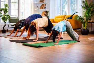 Hintli aile evde Suryanamaskara yapıyor. Sağlıklı vücut için evde güneş selamı yogası yapıyorlar. Ve sabahları modern, savurgan bir yaşam alanında sakin bir zihin.