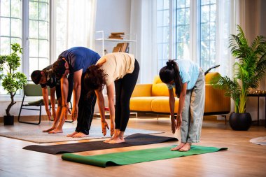 Hintli aile evde Suryanamaskara yapıyor. Sağlıklı vücut için evde güneş selamı yogası yapıyorlar. Ve sabahları modern, savurgan bir yaşam alanında sakin bir zihin.