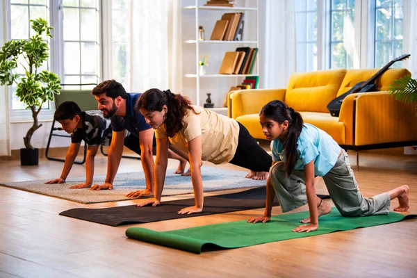Hintli aile evde Suryanamaskara yapıyor. Sağlıklı vücut için evde güneş selamı yogası yapıyorlar. Ve sabahları modern, savurgan bir yaşam alanında sakin bir zihin.