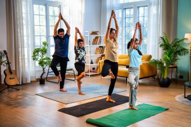 Hintli aile evlerinde parvatasana yogası yapıyor. Dağ yürüyüşü yapıyorlar. Sağlıklı vücut için evde birlikte poz veriyorlar.