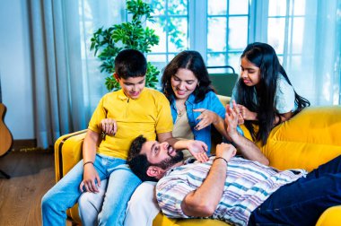 Hintli genç baba evdeki aileye bir hikaye anlatıyor. Oğul ve kız olarak karın kucağında dinlenirken. Kapalı koltukta mutlu bir şekilde dinle.