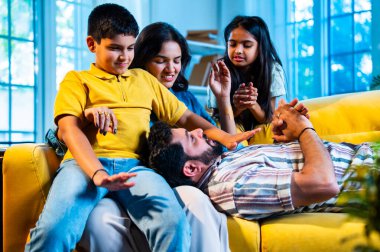 Hintli genç baba evdeki aileye bir hikaye anlatıyor. Oğul ve kız olarak karın kucağında dinlenirken. Kapalı koltukta mutlu bir şekilde dinle.