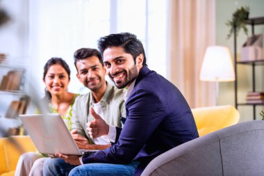 Hintli çift yatırım toplantısı sırasında temsilciyle tartışıyor. İş adamlarıyla mali belgeleri ve dosyaları gözden geçiriyorlar. Bu sırada rahat, modern oturma odasındaki koltukta oturuyorlar.