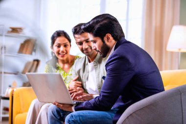 Hintli çift yatırım toplantısı sırasında temsilciyle tartışıyor. İş adamlarıyla mali belgeleri ve dosyaları gözden geçiriyorlar. Bu sırada rahat, modern oturma odasındaki koltukta oturuyorlar.