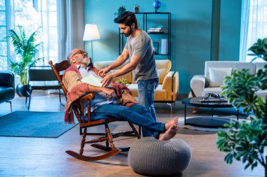 Hintli emekli baba sallanan sandalyeyi rahatlatmak üzerine kitap okurken uyuyakalır. İlgili küçük oğlu şalı nazikçe düzeltir ve evdeki modern oturma odasında kitap ve gözlüğü çıkarır.