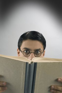 yuvarlak gözlüklü genç kitap okuyucu