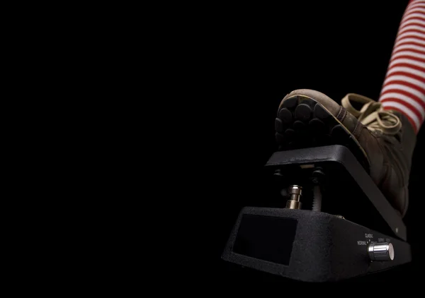 Zapato empujando hacia abajo un negro wah wah pedal de guitarra — Foto de Stock