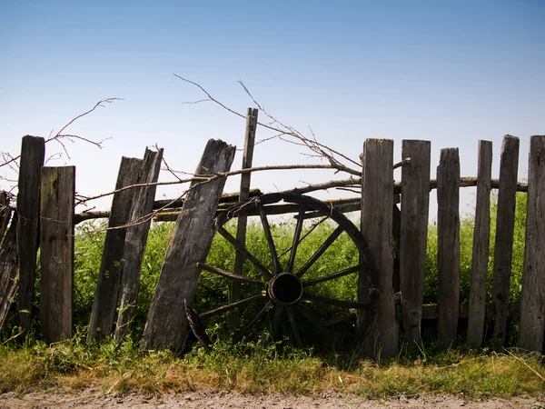 Roue de chariot sur une clôture en bois — Photo