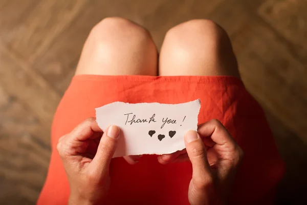 Mujer sosteniendo una nota de agradecimiento en su mano —  Fotos de Stock