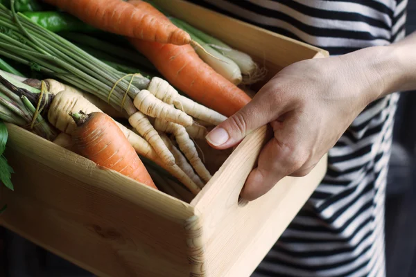 市場で野菜の木枠を保持している女性 — ストック写真