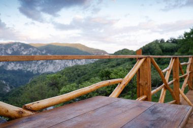 Güvertede ahşap masa manzarası ve dağ manzaralı çit manzarası 