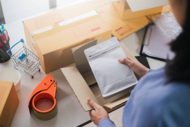 İşçi ya da satıcının, sevkiyat için paketleme ekommerce sipariş kutusuna kızarmış kahve çekirdeklerini paketlediği en iyi manzara. Postacı teslimat paketi, iş çevrimiçi ve sevkiyat hizmeti hazırlanıyor.