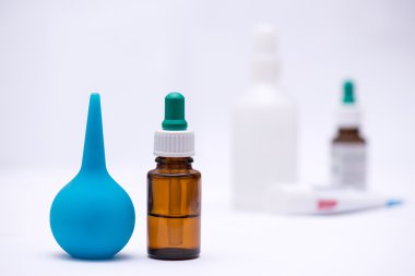 -bir şişe ilaç ve arka plan tüpler ve şırınga, ön planda bir termometre