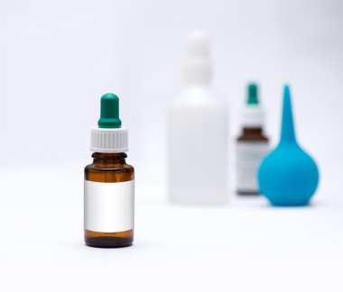 ön planda, arka plan tüpler ve şırınga beyaz etiketli bir kahverengi şişe