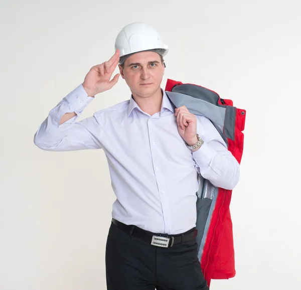 Mężczyzna w czerwonej kurtce, trzymając rękę kask biały budowlanych — Zdjęcie stockowe