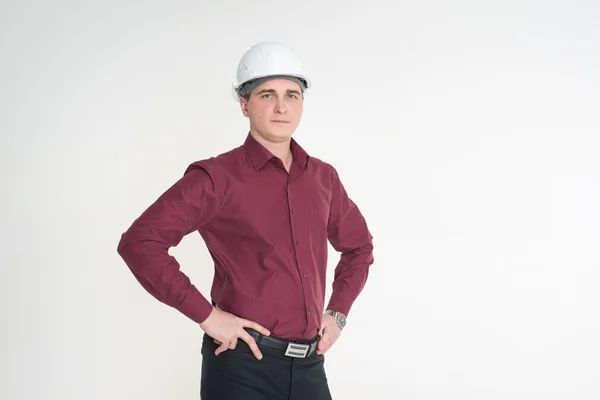 Un hombre con una camisa marrón y en el casco de construcción —  Fotos de Stock