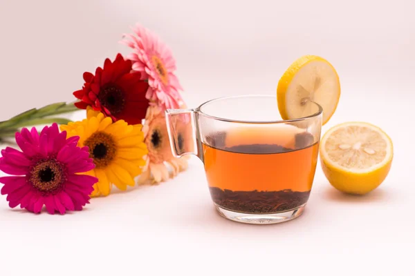 Tea in glass mug, lemons and flowers — Stock Photo, Image