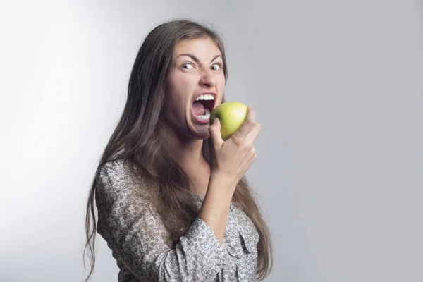 Hungry and angry woman with green apple — Stock Photo, Image