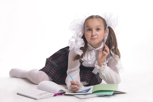 Estudante com arcos brancos em uniforme escolar aparece em um fundo branco — Fotografia de Stock