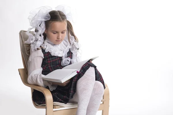 Beyaz bir arka plan üzerinde beyaz yay okul üniforması ile kız öğrenci ortaya