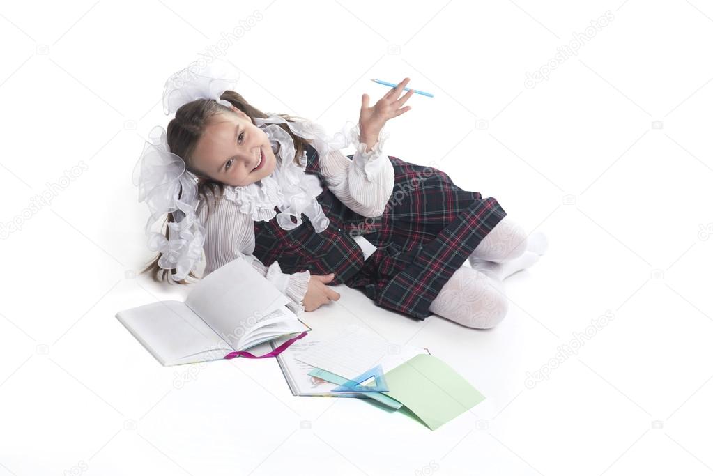 Schoolgirl with white bows in school uniform shows up on a white background