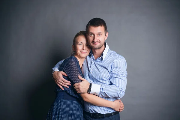 Rodinný šťastnému páru v ateliéru na šedém pozadí — Stock fotografie