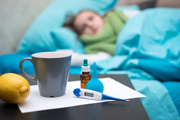 Un bébé malade couché au lit avec un thermomètre — Photo