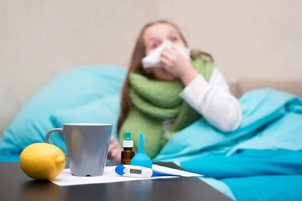 Bir termometre ile yatakta yatan bir hasta bebek