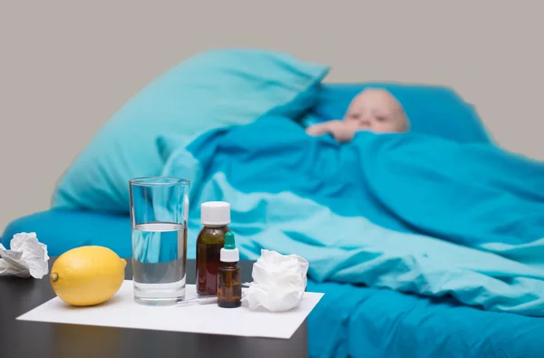 Um bebê doente deitado na cama — Fotografia de Stock