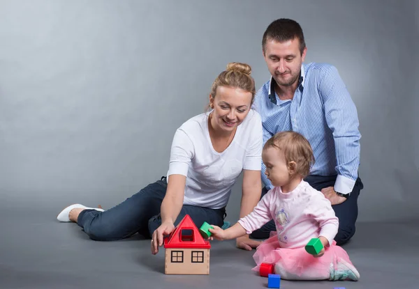 Anne, baba ve bebek bir oyuncak ev inşa ediyoruz