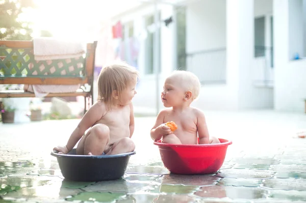 İki çocuk erkek ve kız havzalarında oturup konuşmak