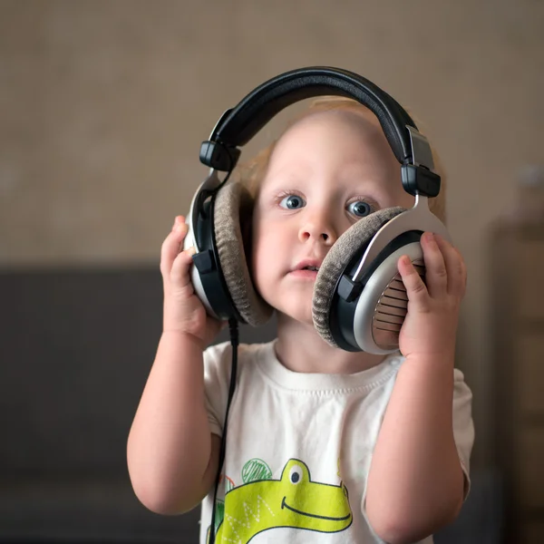 El niño escucha música en los auriculares —  Fotos de Stock