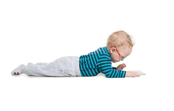 Kleiner Junge mit Brille sitzt mit Tablet auf dem Boden — Stockfoto