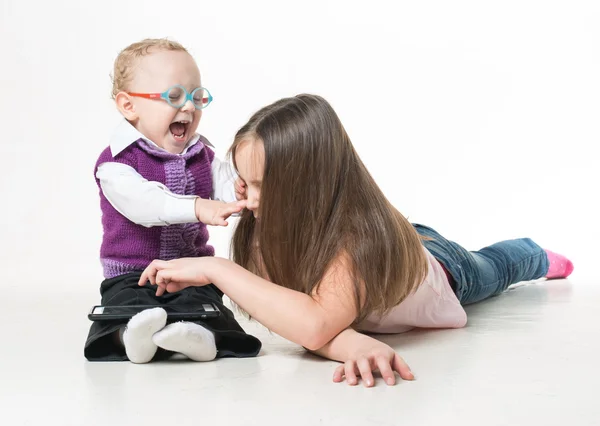 Очень умный маленький мальчик в очках играет со своей старшей сестрой — стоковое фото