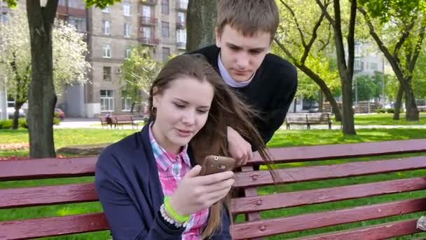 Menino e menina usando telefone móvel.Fora . — Vídeo de Stock