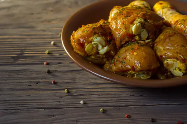 Çiğ tavuk budu baharat yalan bir tepside ile kaplı. Arka plan. Biber renk