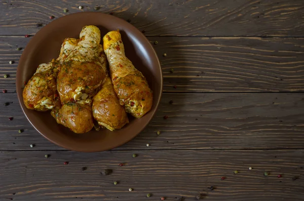 Yukarıdan görüntüleyin. Çiğ tavuk budu baharat yalan bir tepside ile kaplı. Arka plan. Biber renk.