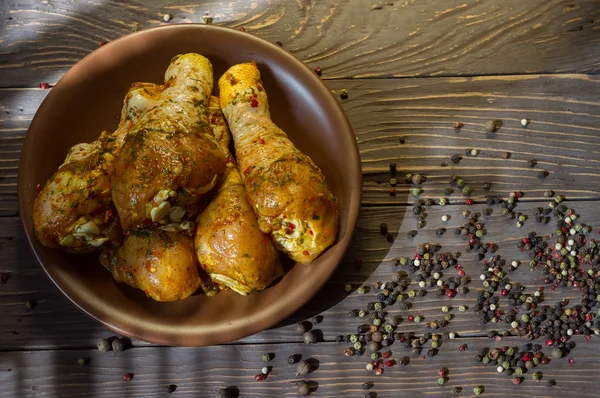 Arka plan. Çiğ tavuk budu baharat yalan bir tepside ile kaplı. Arka plan. Ufalanmış biber renk. Yukarıdan görüntülemek